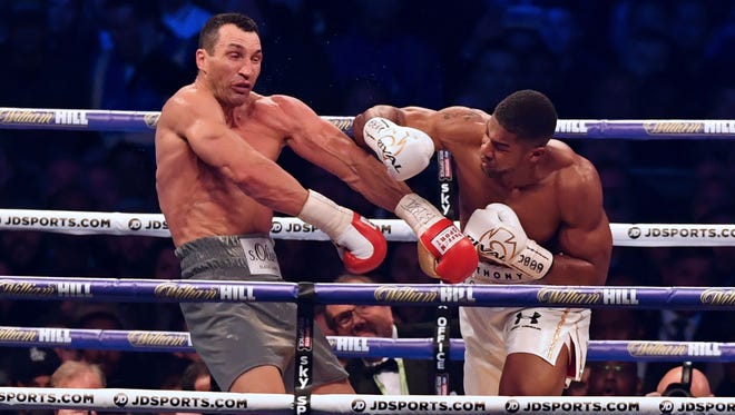 Britain's Anthony Joshua (R) throws a punch at Ukraine's Wladimir Klitschko during the fourth round of their IBF, IBO and WBA, world Heavyweight title fight at Wembley Stadium.