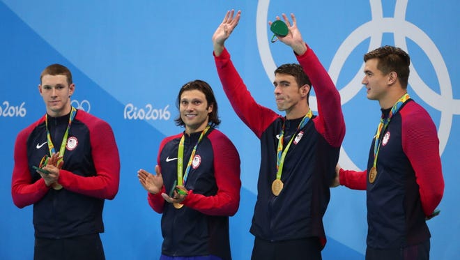 Michael Phelps and teammates celebrate on the podium after winning the men's 4x100-meter medley.