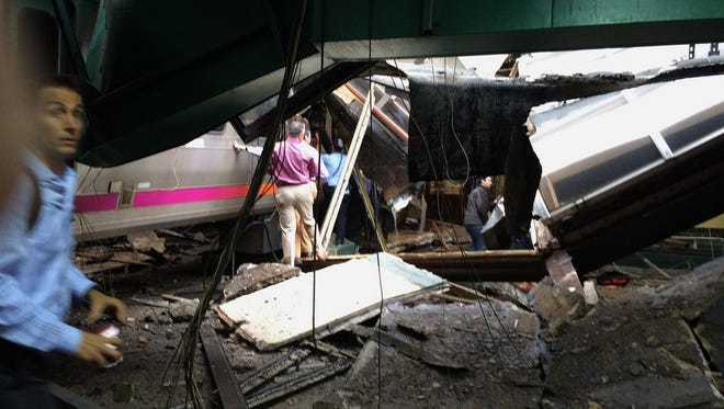 People examine the wreckage of a New Jersey Transit commuter train that crashed.