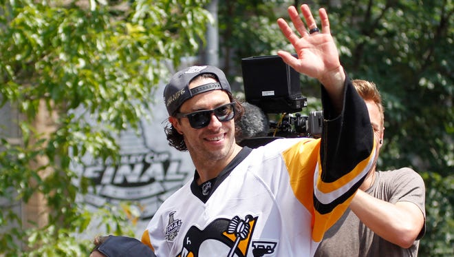 Pittsburgh Penguins center Matt Cullen (7) waves to the crowd during the Stanley Cup championship parade and rally in downtown Pittsburgh. Mandatory Credit: Charles LeClaire-USA TODAY Sports