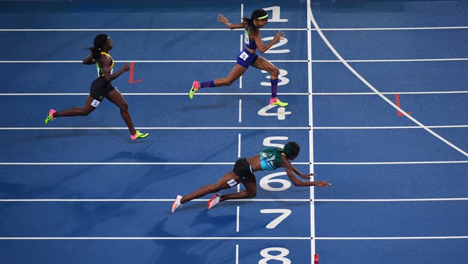 Shaunae Miller of the Bahamas, bottom, dives across the finish line to win gold in the 400 meters ahead of American Allyson Felix, top.