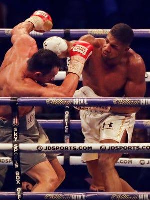 Anthony Joshua, right, delivers a blow to Wladimir Klitschko on the way to a TKO victory Saturday.