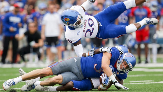 Kansas wide receiver Chase Harrell takes safety Emmanuel Moore off his feet after a catch during the team's spring game.