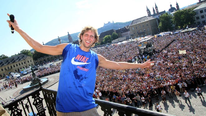 2011: Dirk Nowitzki poses on a balcony of the Wuerzburg Residence in Wuerzburg, southern Germany while thousands of fans watch from the square.