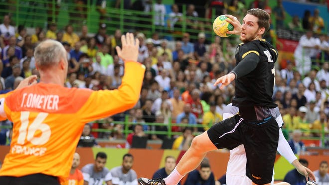 Germany midfield Sara Dabritz (13) shoots against France goalkeeper Thierry Omeyer (16) during the men's handball semifinals.