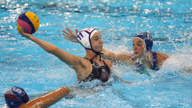 U.S. center back Makenzie Fischer (11) looks to shoot between a pair of Italy defenders during the women's water polo gold medal match.
