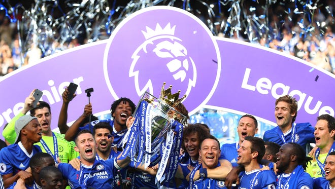 Chelsea players celebrate with the Premier League trophy.