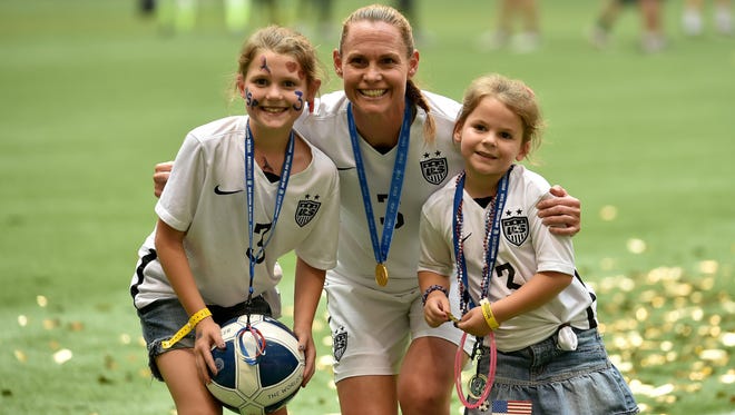 U.S. women's soccer player Christie Rampone celebrates with daughters Rylie and Reece.