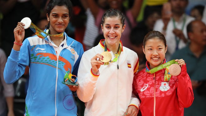 Carolina Marin of Spain is flanked by V. Sindhu Pusarla of India, left, and Nozomi Okuhara of Japan after winning gold in women's singles badminton at Riocentro - Pavilion 4 during the Rio 2016 Summer Olympic Games.
