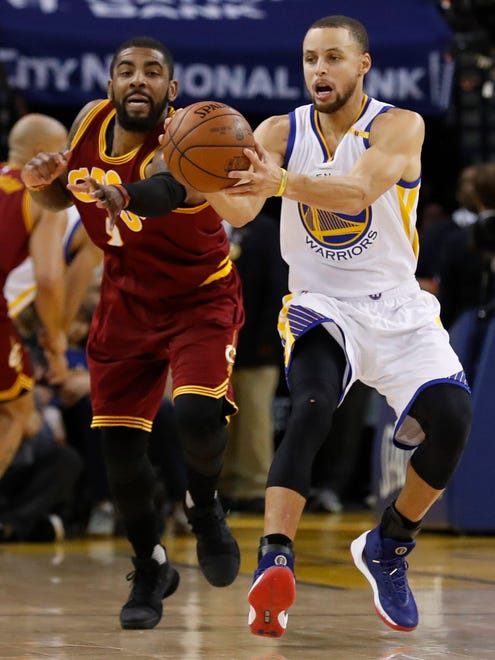 Stephen Curry grabs a pass as Kyrie Irving reaches out to steal.