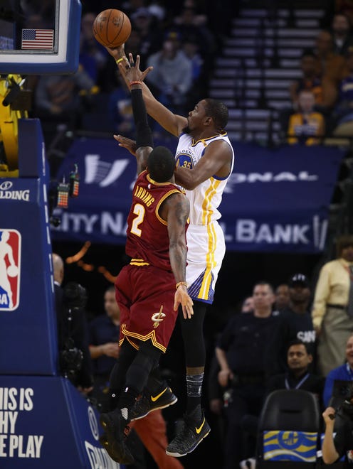Kevin Durant goes up for a shot against Kyrie Irving at Oracle Arena.