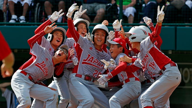 Tokyo, Japan's Natsuki Yajima (20) celebrates with teammates after hitting a two-run home run off White Rock, British Columbia pitcher Reece Ussleman in the third inning of an International game at the Little League World Series.