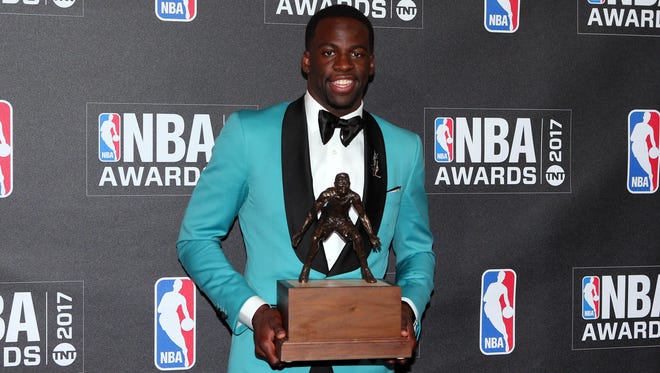 Draymond Green poses for photos with his defensive player of the year award during the 2017 NBA Awards.