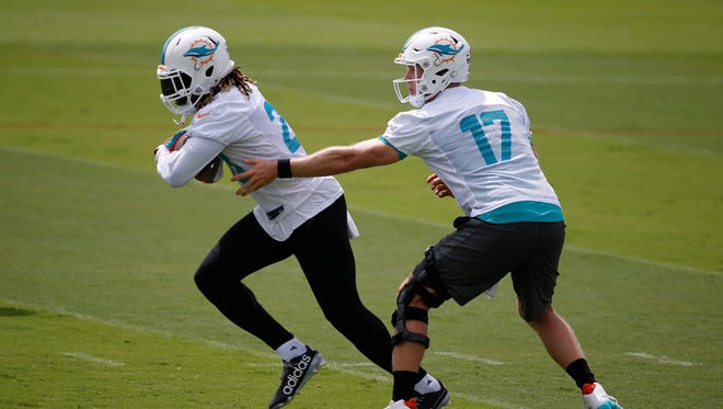 Miami Dolphins quarterback Ryan Tannehill (17) hands off to running back Jay Ajayi during an NFL organized team activities football practice, Wednesday, May 31, 2017, at the Dolphins training facility in Davie, Fla.