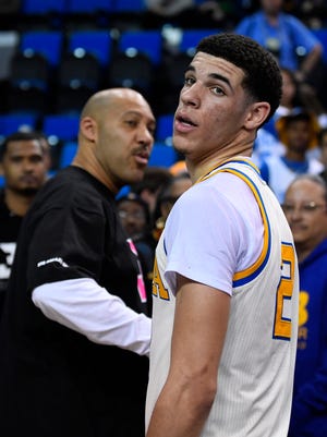 UCLA guard Lonzo Ball, right, walks away after hugging his father, LaVar, following the team's NCAA college basketball game against Washington State in Los Angeles.