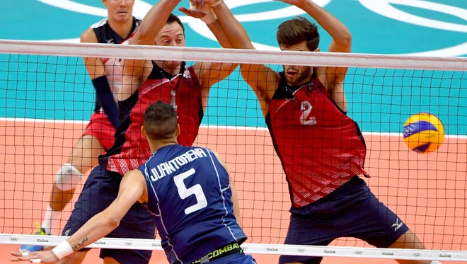 Matthew Anderson, left, and Aaron Russell of the United States attempt to block the spike of Osmany Juantorena of Italy in a men's semifinals volleyball match at Maracanazinho during the Rio 2016 Summer Olympic Games.