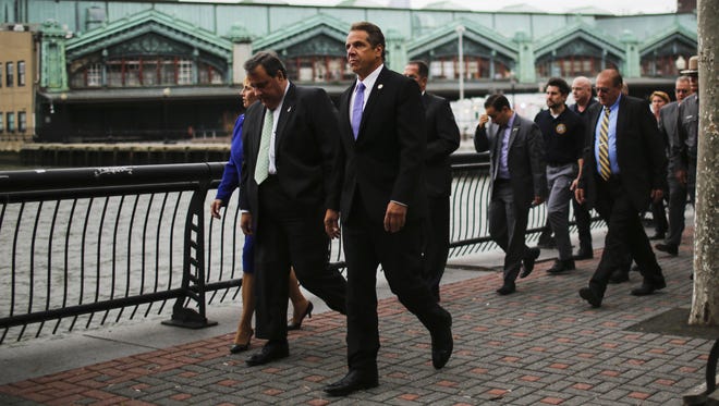 New Jersey Governor Chris Christie, left, and New York Governor Andrew Cuomo  arrive at the Hoboken Terminal to speak at a press conference .