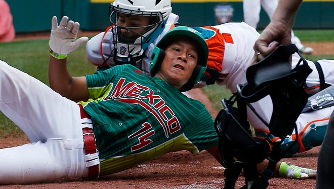 Mexico's Cesar Monjaraz slides around the attempted tag by Venezuela catcher Luis Rodriguez to score on a single by Carlos Garcia in the second inning of an International elimination baseball game at the Little League World Series.