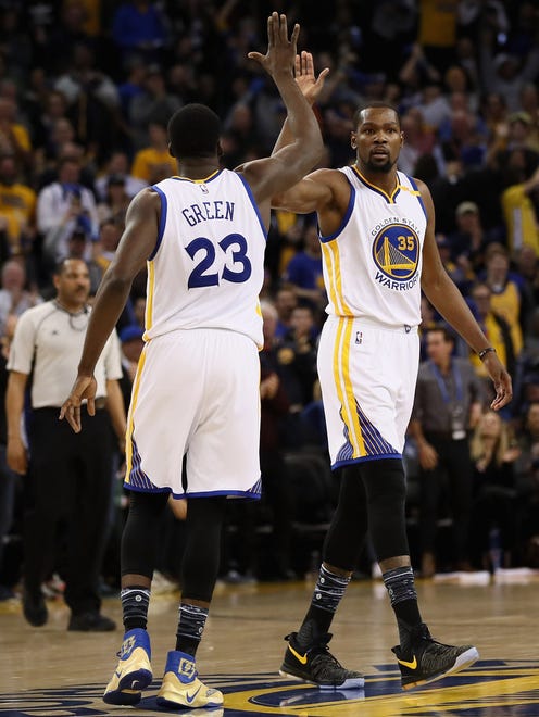 Draymond Green high fives Kevin Durant during their game against the Cleveland Cavaliers.