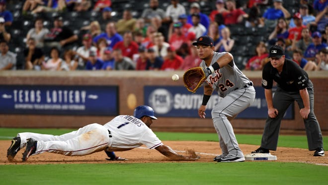 Rangers shortstop Elvis Andrus (1) dives safely back to first ahead of the tag of Tigers first baseman Miguel Cabrera (24) on a pick-off attempt in the eighth inning of the Tigers' 10-4 loss to the Rangers on Tuesday, Aug. 15, 2017, in Arlington, Texas.