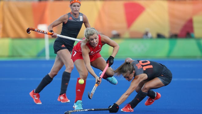 Great Britain midfield Georgie Twigg and Netherlands forward Kelly Jonker battle for the ball during the field hockey gold medal match.