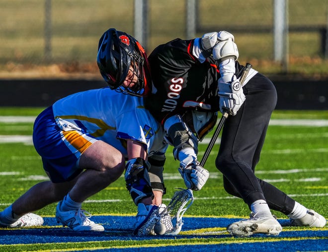 Catholic Memorial's David Hansen, left, faces off with Cedarburg's Vince Rosenberg (1) during the lacrosse match at Catholic Memorial on Wednesday, March 20, 2024. Cedarburg won 6-5.
