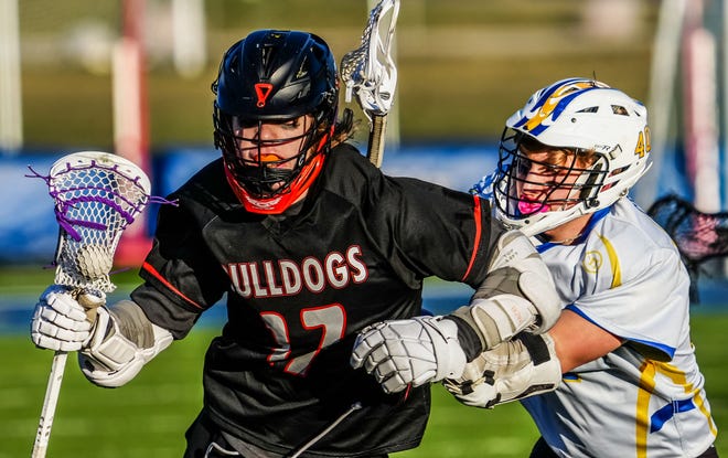 Cedarburg's Damien Pendzick (17) protects the ball from Catholic Memorial's Ben Schloemer (37) during the lacrosse match at Catholic Memorial on Wednesday, March 20, 2024.