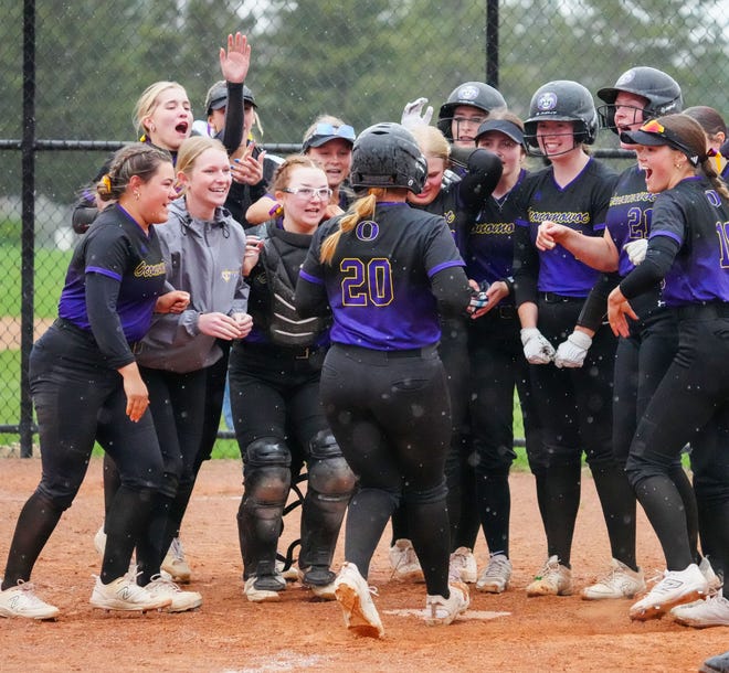 Oconomowoc teammates welcome Macy Brazelton (20) to home plate after she hit a home run in the game at Arrowhead, Tuesday, April 16, 2024.