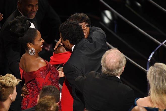 How sweet! Davis receives a hug from "Fences" co-star Denzel Washington after winning the Oscar for best supporting actress at the 89th Academy Awards in February 2017.