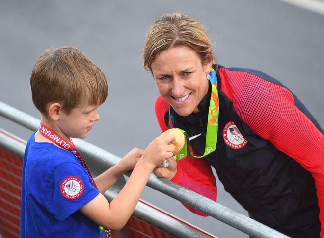 Olympic cyclist Kristin Armstrong shows her gold medal to her son Lucas at the Rio Games in 2016.